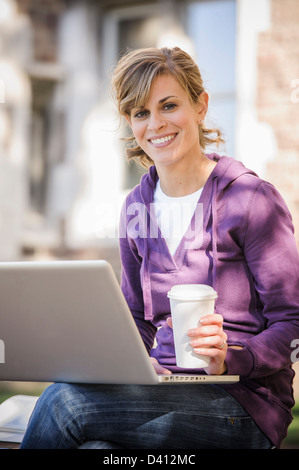 Caucasian student using laptop on campus Stock Photo
