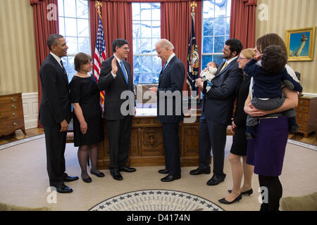 US President Barack Obama watches as Vice President Joe Biden swears in Treasury Secretary Jack Lew during a ceremony in the Oval Office February 28, 2013 in Washington, DC. Lew's family, pictured from left, are: wife Ruth Schwartz;  granddaughter Eliora Lew; son Danny Lew; daughter Shoshana Lew; daughter-in-law Zahava Lew;  and grandson Moshe Lew. Stock Photo