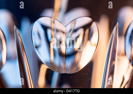 Detail of a cut glass champagne goblet with a heart on the side and drink being poured Stock Photo