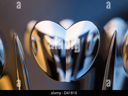 Detail of a cut glass champagne goblet with a heart on the side and reflecting lights from background Stock Photo