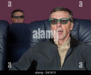 Senior male with shocked expression watching movie in home theater in 3d glasses Stock Photo