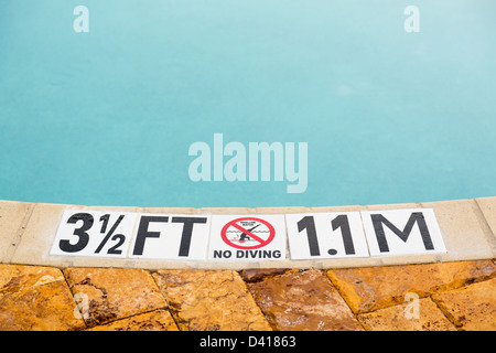 Sign showing 3.5 ft depth on edge of blue swimming pool with no diving Stock Photo