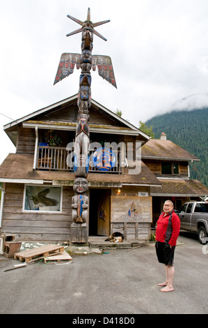 Portrait of a Nuxalk carver and elder standing beside his totem pole in the native reserve town of Bella Coola, British Columbia, Canada. Stock Photo