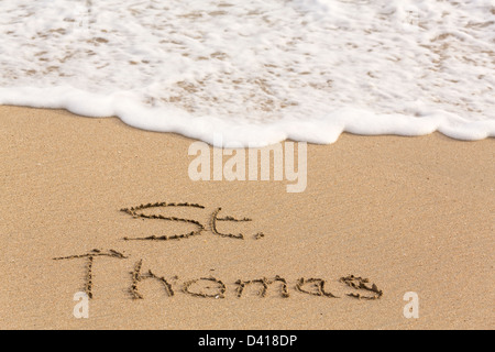 St Thomas words written into sand on beach by sea in Caribbean Stock Photo