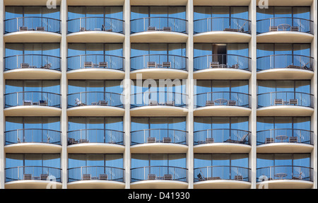 Pattern of hotel room balconies in modern building with one patio door open Stock Photo