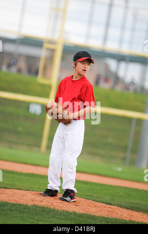 Young baseball player looking at the batter. Stock Photo