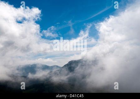 Fog at morning sunrise rolling over hills in Western Ghats Sahyadri Stock Photo