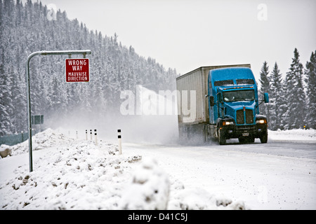 Wrong way sign and transport truck on Trans-Canada Highway in winter conditions near Lake Louise, Alberta, Canada. Stock Photo