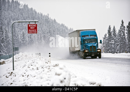 Wrong way sign and transport truck on Trans-Canada Highway in winter conditions near Lake Louise Stock Photo