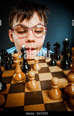 Teenage boy learning to play chess online with tablet computer