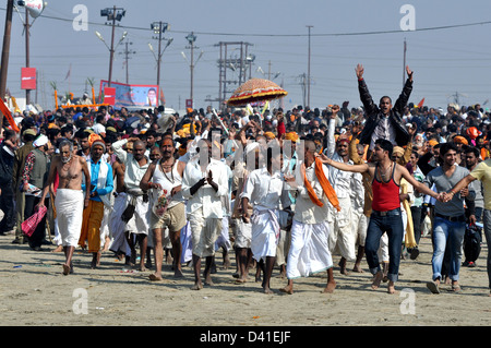 Hindu devotees run in to take to bathe in the waters of the holy Ganges river during the auspicious bathing day. Stock Photo