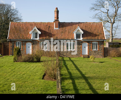 Small symmetrical estate cottages and gardens divided by fence, Bawdsey, Suffolk, England Stock Photo