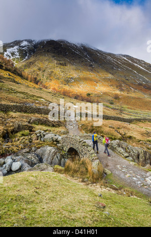 Grains Gill and walkers walking over Stockley Bridge with Base Brown, Cumbria, Lake District, England, UK Stock Photo