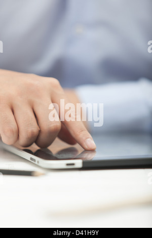 Hands of the man in the blue shirt are holding a tablet computer Stock Photo