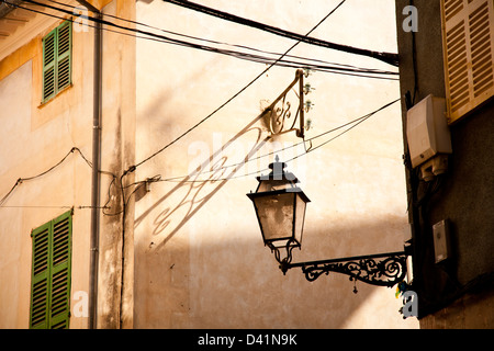 Close-up of buildings in Valldemossa, Majorca, Spain with an ornate street lamp and house with green shutters. Stock Photo