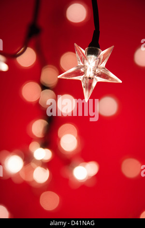 Star shaped Christmas tree lights against red with very shallow depth of field. Stock Photo