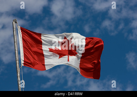 The Canadian maple leaf red and white flag flying over Rustico in Prince Edward Island Stock Photo