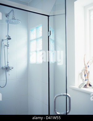 Close-up of large chrome shower in glass shower cabinet in modern white bathroom Stock Photo