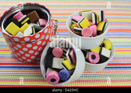 A container and three bowls full of liquorice sweets. Stock Photo