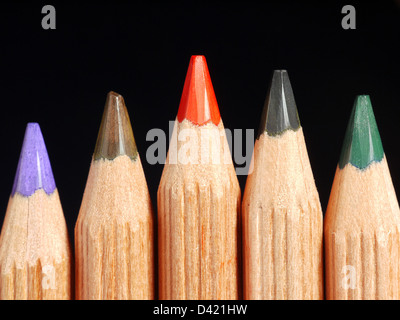 Closeup of row of colorful wooden crayons shot over black background Stock Photo