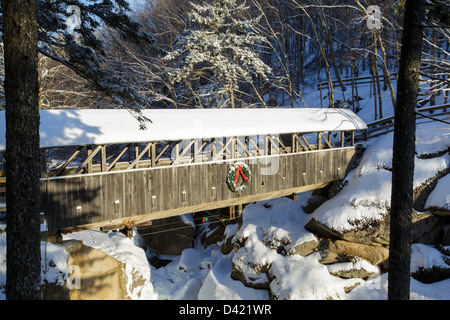 Sentinel Pine Covered Bridge during the winter months. It is a footbridge which crosses over the Pemigewasset River in Lincoln, New Hampshire Stock Photo