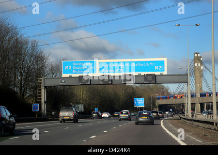 M3 Junction on M25 Train On Bridge Crossing Motorway England Stock Photo