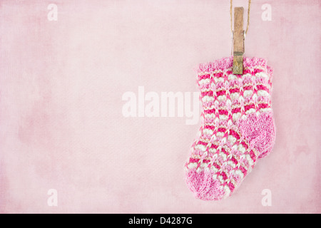 Baby girl woolen socks on textured pastel pink background Stock Photo