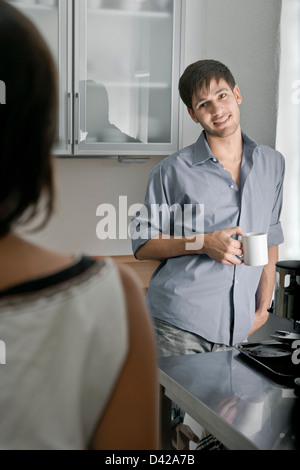 A man and woman chatting in the kitchen over a fresh cup of coffee Stock Photo