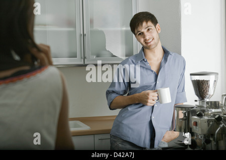 A man and woman chatting in the kitchen over a fresh cup of coffee Stock Photo