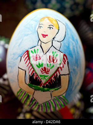 A painted egg with a woman in a traditional dress sits in the Spree Forest Museum in Luebbenau, Germany, 02 March 2013. At the two-day Easter egg fair exhibitors show their different techniques of the art of painting eggs. Photo: PATRICK PLEUL Stock Photo