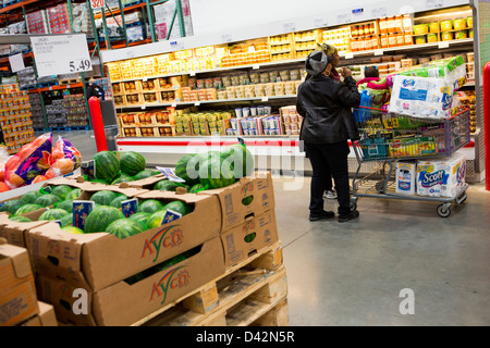 Customers shopping in the produce section of a Costco Wholesale Warehouse Club. Stock Photo