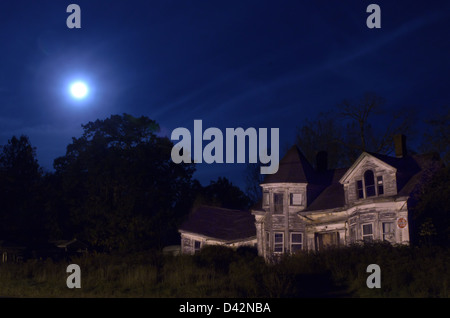 A full moon hovers over an abandoned house in Searsport, Maine Stock Photo