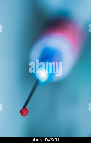 Close up of syringe needle point with drop of blood. Stock Photo