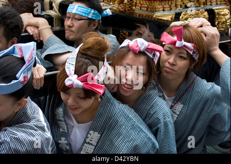 Women carry a gold decorated sacred mikoshi portable shrine in the Sanja Matsuri Festival, one of Tokyo's big three events. Stock Photo