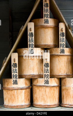 A stack of old traditional wooden water buckets for putting out fires at a temple in Tokyo. Stock Photo