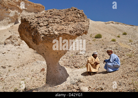 Omani men with desert mushroom near Mazara, Oman Stock Photo