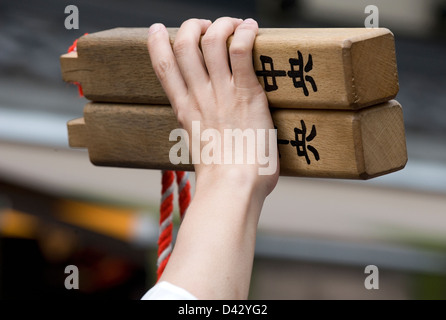 Man holding up a pair of hiyoshigi (wooden clapper sticks) signaling his team to stop during a Sanja Matsuri Festival parade. Stock Photo