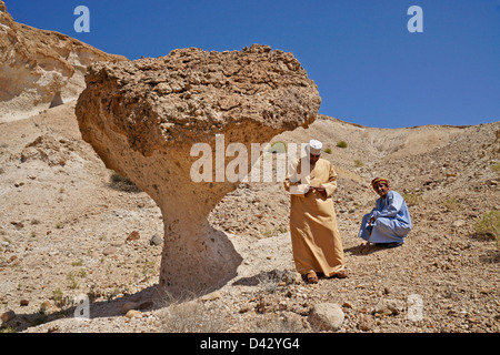 Omani men with desert mushroom near Mazara, Oman Stock Photo