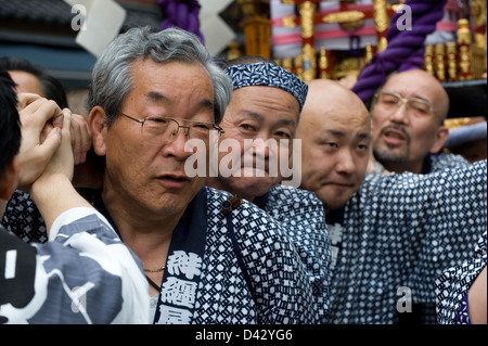 Men carry a gold decorated sacred mikoshi portable shrine in the Sanja Matsuri Festival, one of Tokyo's big three events. Stock Photo