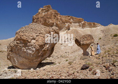 Omani men with desert mushroom near Mazara, Oman Stock Photo