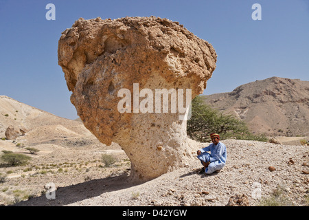 Omani man with desert mushroom near Mazara, Oman Stock Photo