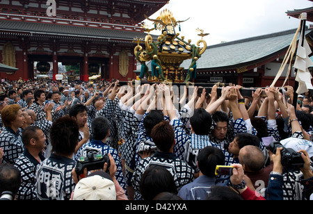 Gold decorated sacred mikoshi portable shrine carried around Sensoji Temple Hozomon Gate during Sanja Matsuri Festival. Stock Photo