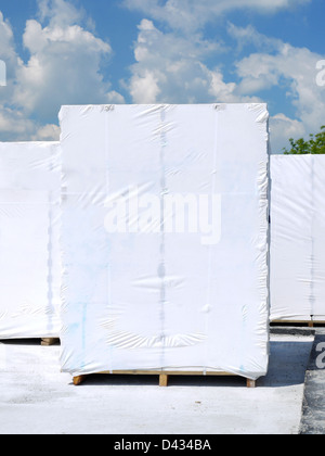 White foiled aerated autoclaved concrete blocks stacked on wooden pallets at the construction site Stock Photo