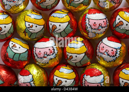 Christmas foil wrapped chocolate balls with snowmen and Father Christmas, Santa Claus, on chocolates ready for Christmas Stock Photo