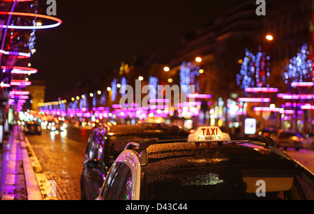 Taxi in Paris with the illuminated for Christmas Champs Elysées  and Arc de Triumph background Stock Photo