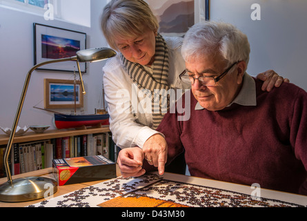 OAPs, RETIRED COUPLE, HUSBAND AND WIFE, WITH JIGSAW Stock Photo