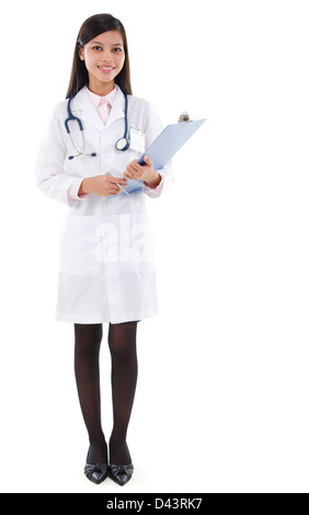 Full body Southeast Asian female medical doctor holding a clipboard standing isolated on white background. Stock Photo