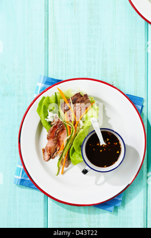 Overhead View of Meat in Lettuce Wrap with Sauce on the Side on Table Stock Photo