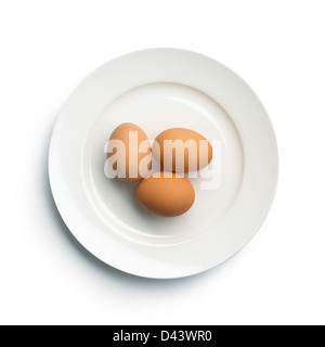 Group of three hard boiled eggs on plate cut out white background Stock Photo