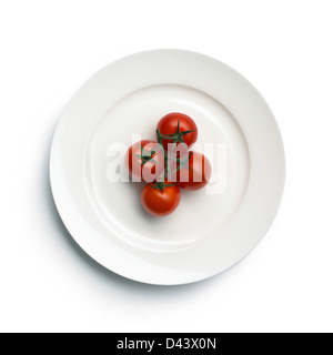 Four cherry tomatoes on plate cut out white background Stock Photo